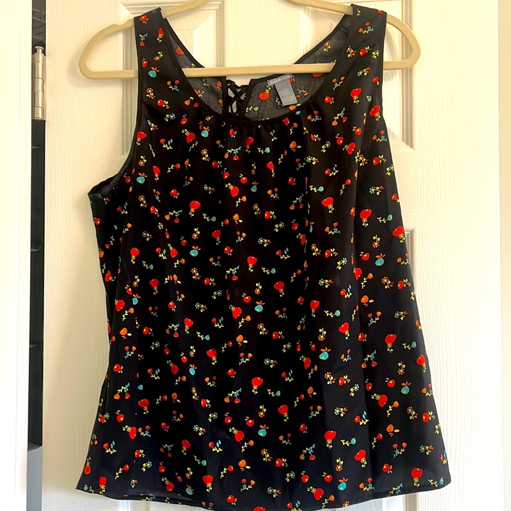 Black/pattern sleeveless top with cross ties at the back & cutout at the back